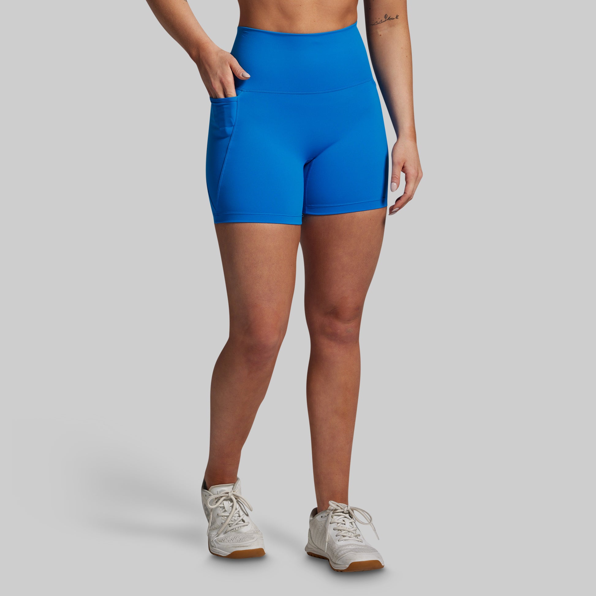 Person wearing blue athletic shorts on a gray background