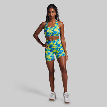 Woman wearing a colorful floral sports outfit on a gray background