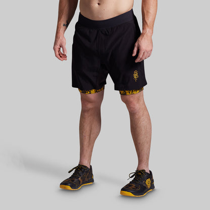 Person wearing black athletic shorts with yellow accents on a gray background