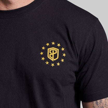 Black t-shirt with a yellow emblem featuring a shield and stars on a gray background