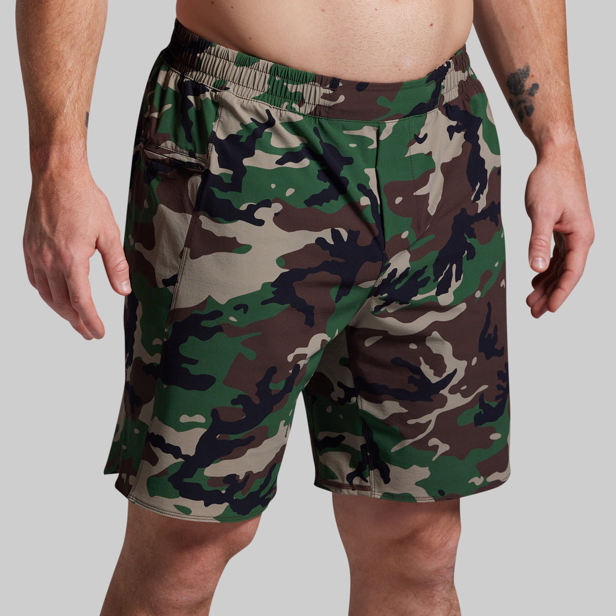 Camouflage shorts worn by a person on a plain background