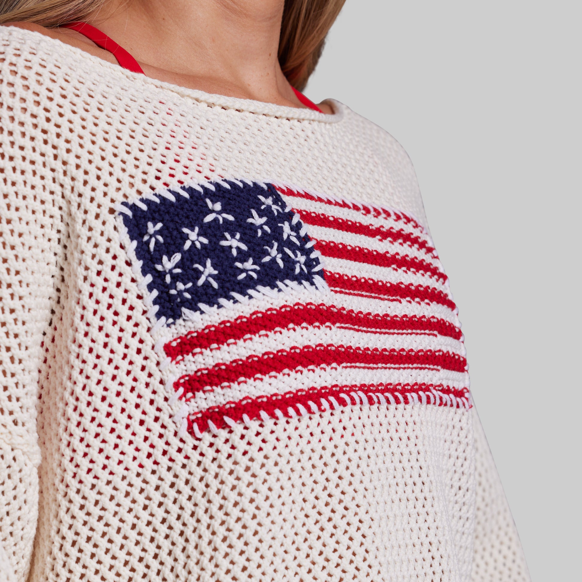 White sweater with American flag design on a plain background