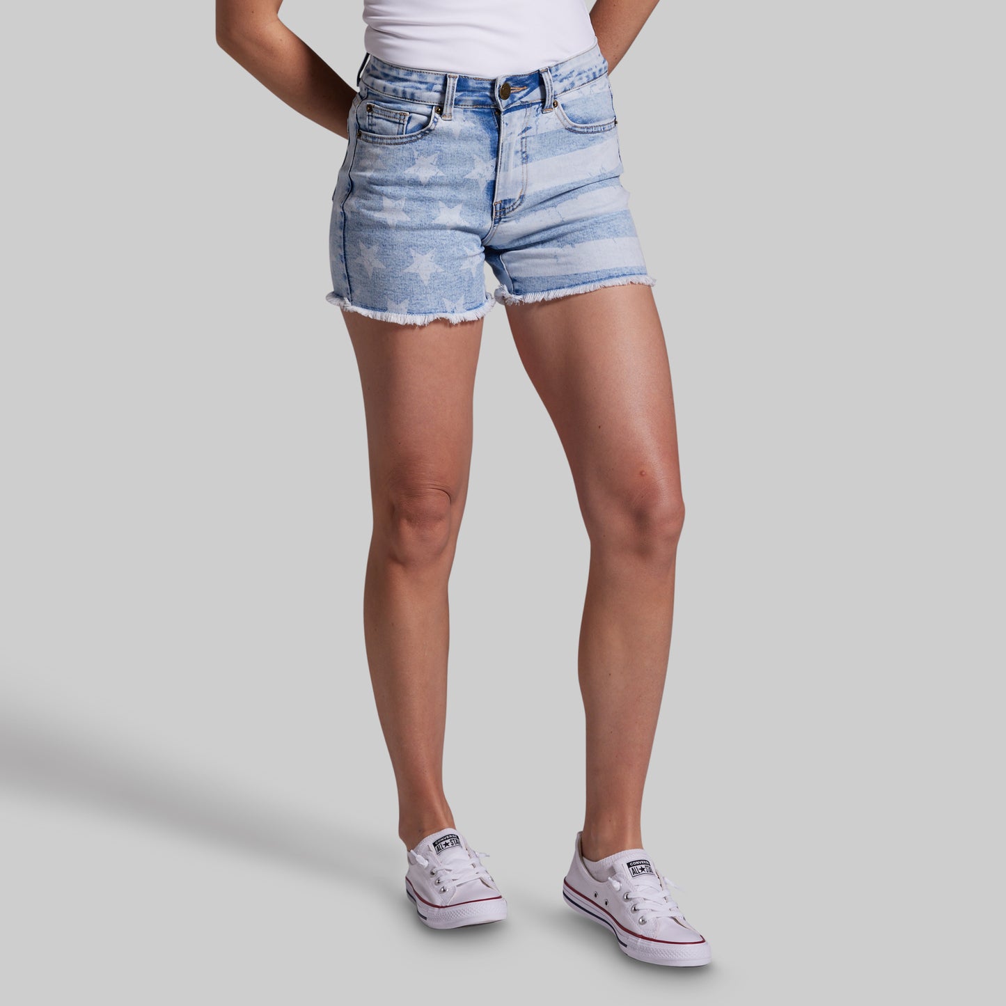 Person wearing light blue denim shorts on a gray background