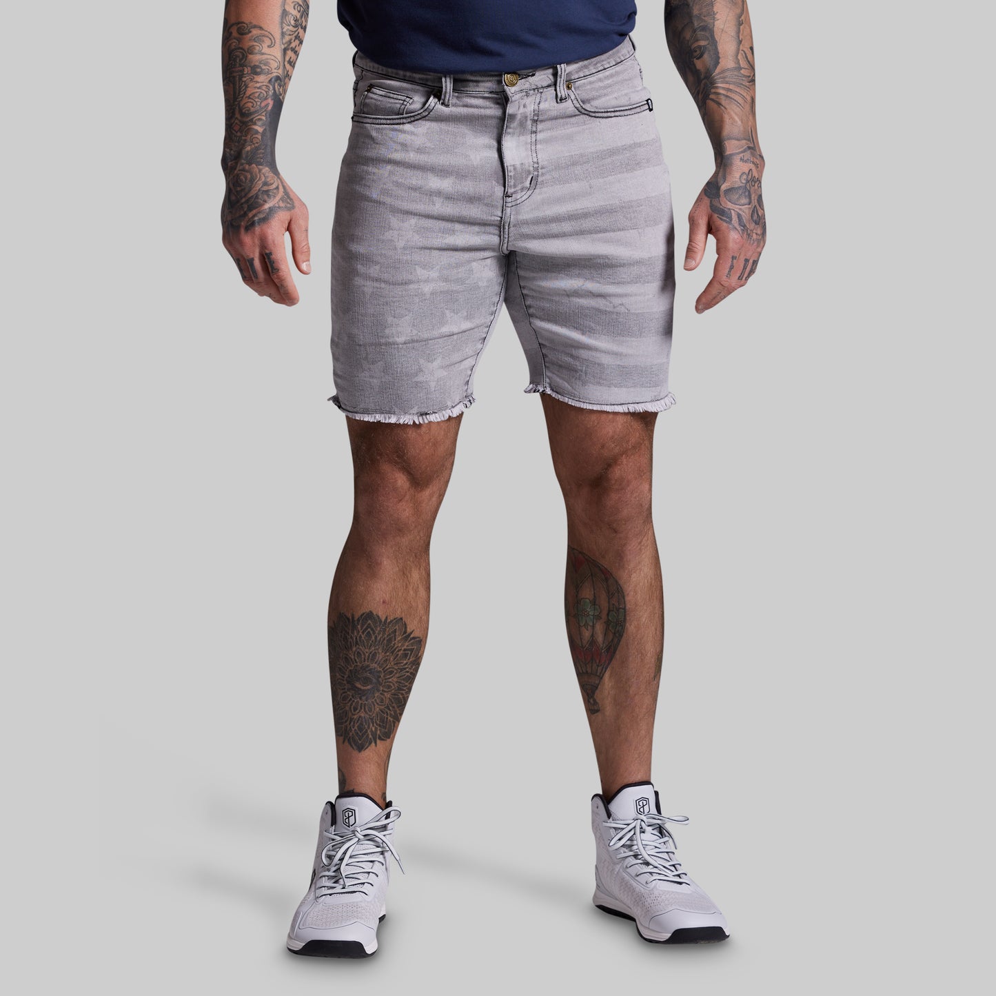Person wearing light gray denim shorts on a plain background