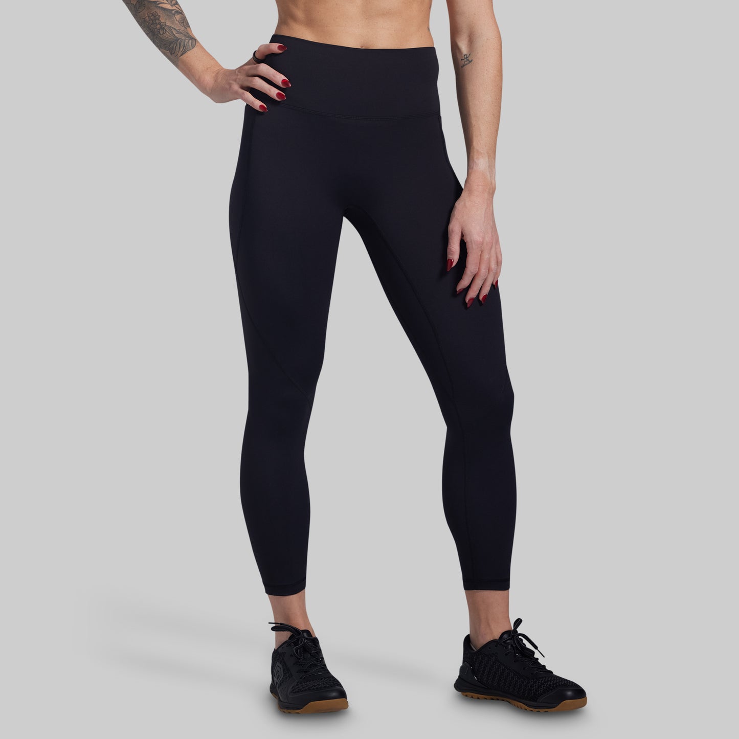 Person wearing black leggings on a gray background