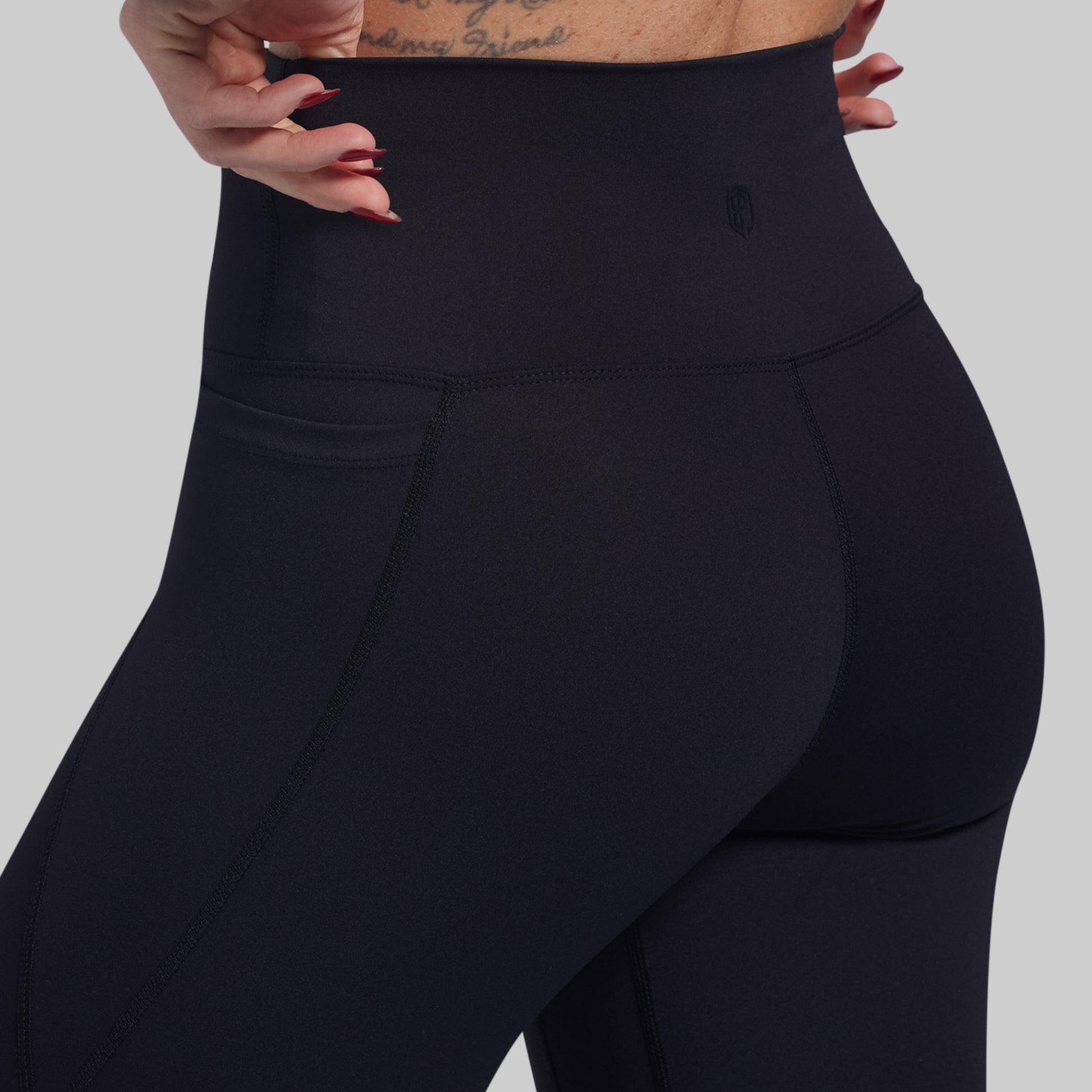 Black leggings worn by a person on a gray background