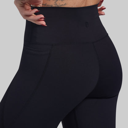 Black leggings worn by a person on a gray background
