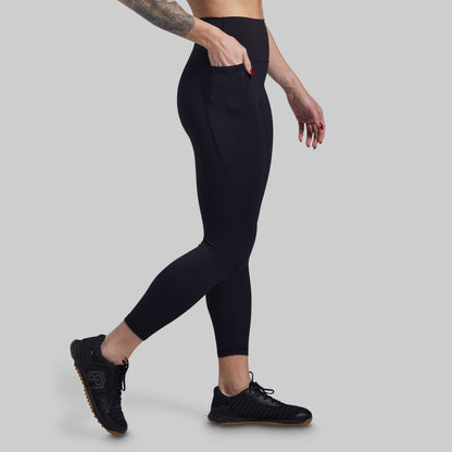 Person wearing black leggings on a gray background
