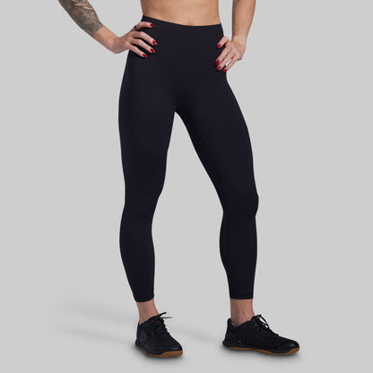 Person wearing black leggings on a gray background