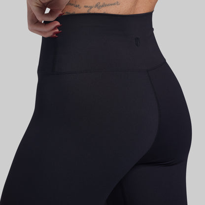 Black high-waisted leggings on a gray background