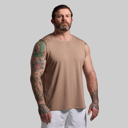Man wearing a beige tank top against a plain background