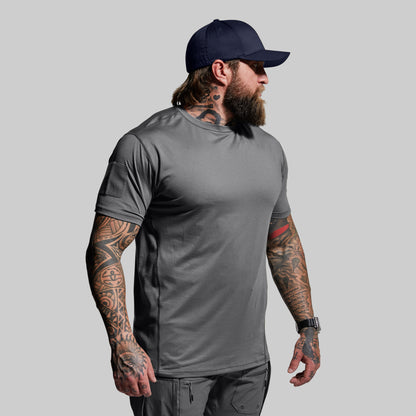 Man wearing a gray t-shirt and navy cap on a light gray background