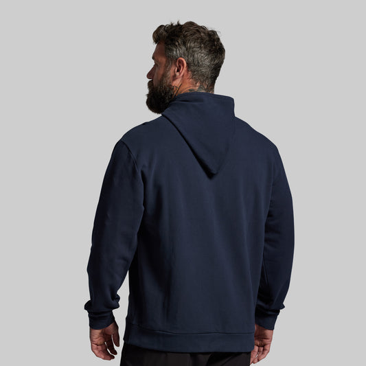 Man wearing a navy blue hoodie on a light gray background