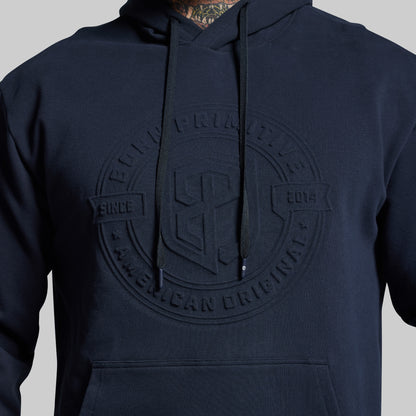 Navy blue hoodie with a logo on the chest against a gray background