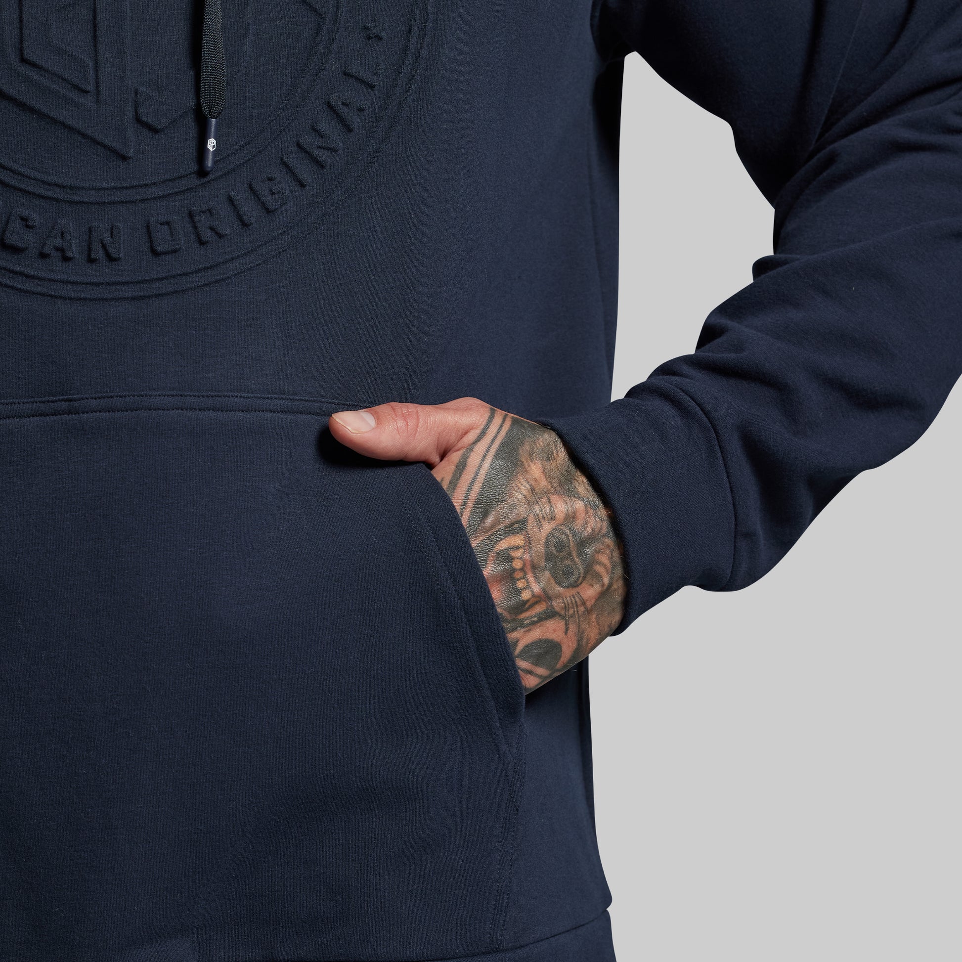 Navy blue hoodie with a brand logo on a gray background