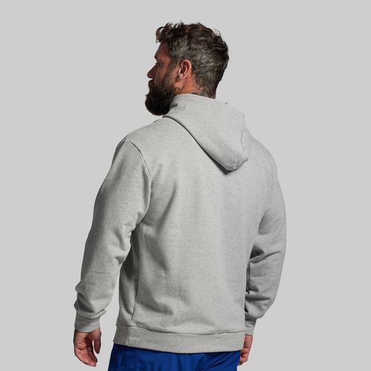 Man wearing a gray hoodie from behind on a light gray background