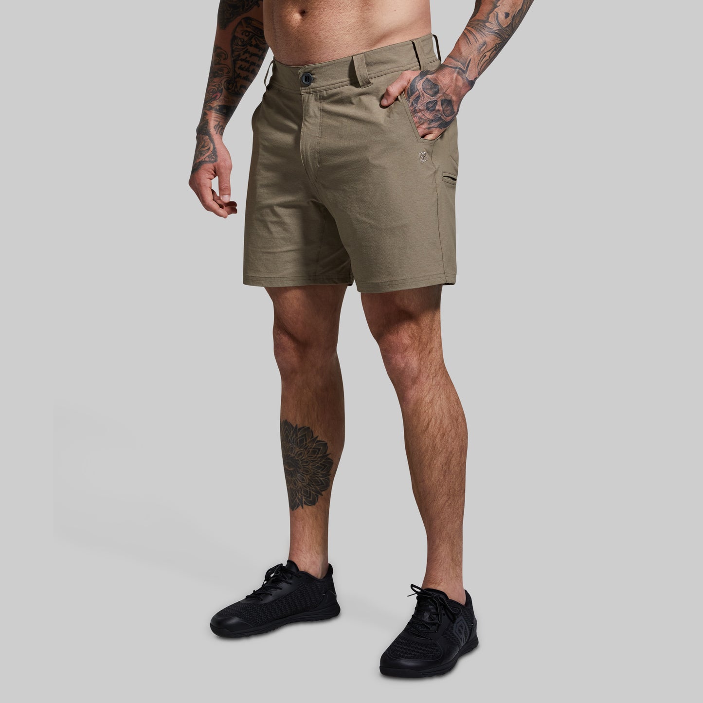 Person wearing khaki shorts on a gray background