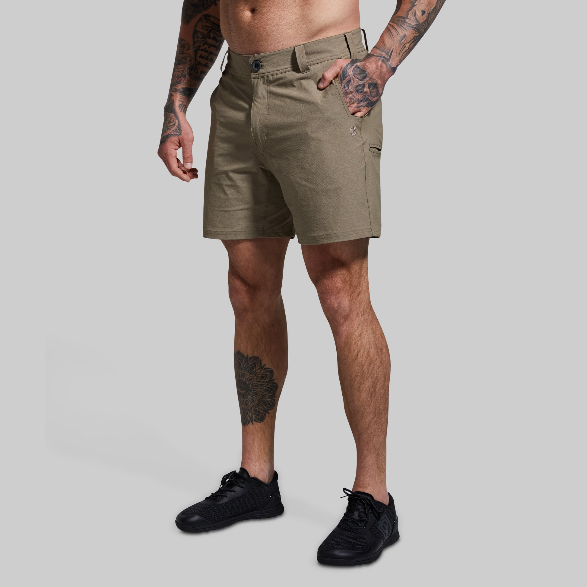 Person wearing khaki shorts on a gray background