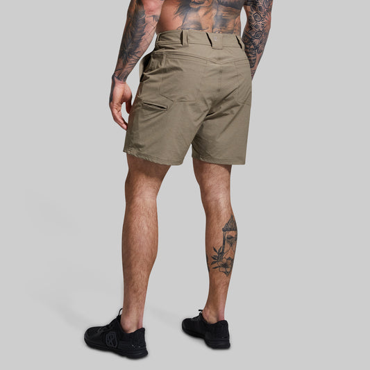 Person wearing khaki shorts on a gray background