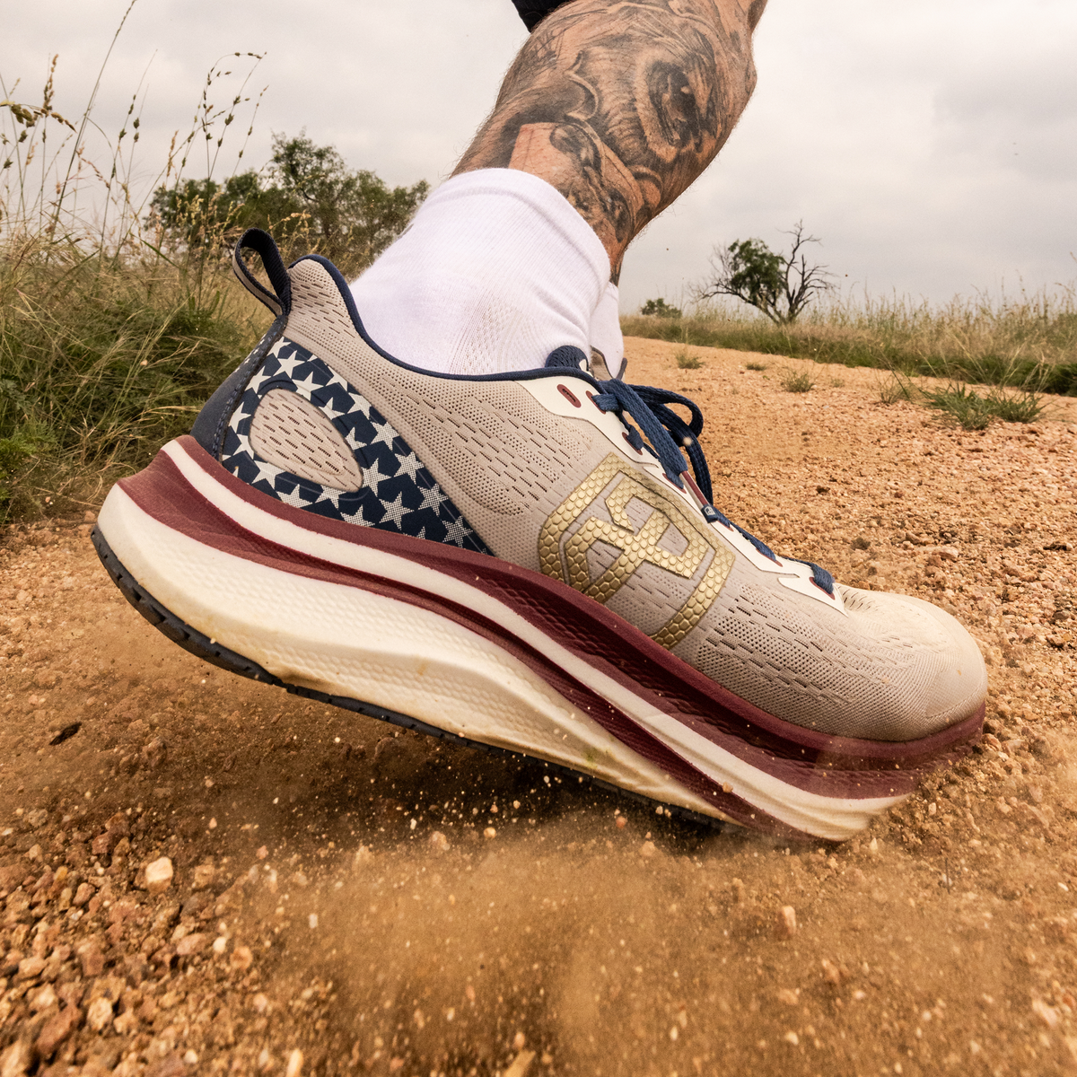 Close-up of a running shoe on a dirt path with a blurred background