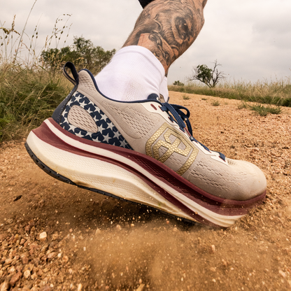 Close-up of a running shoe on a dirt path with a blurred background