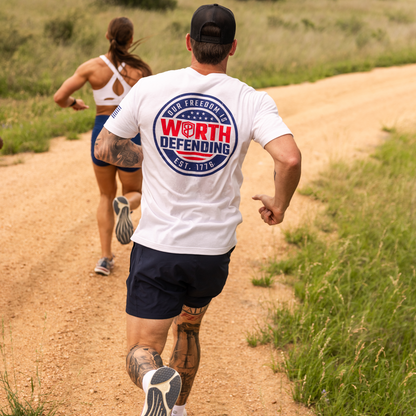 Man and woman running on a dirt path with a 'Worth Defending' t-shirt.