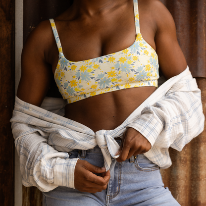 Person wearing a floral bralette and jeans with an unbuttoned shirt.