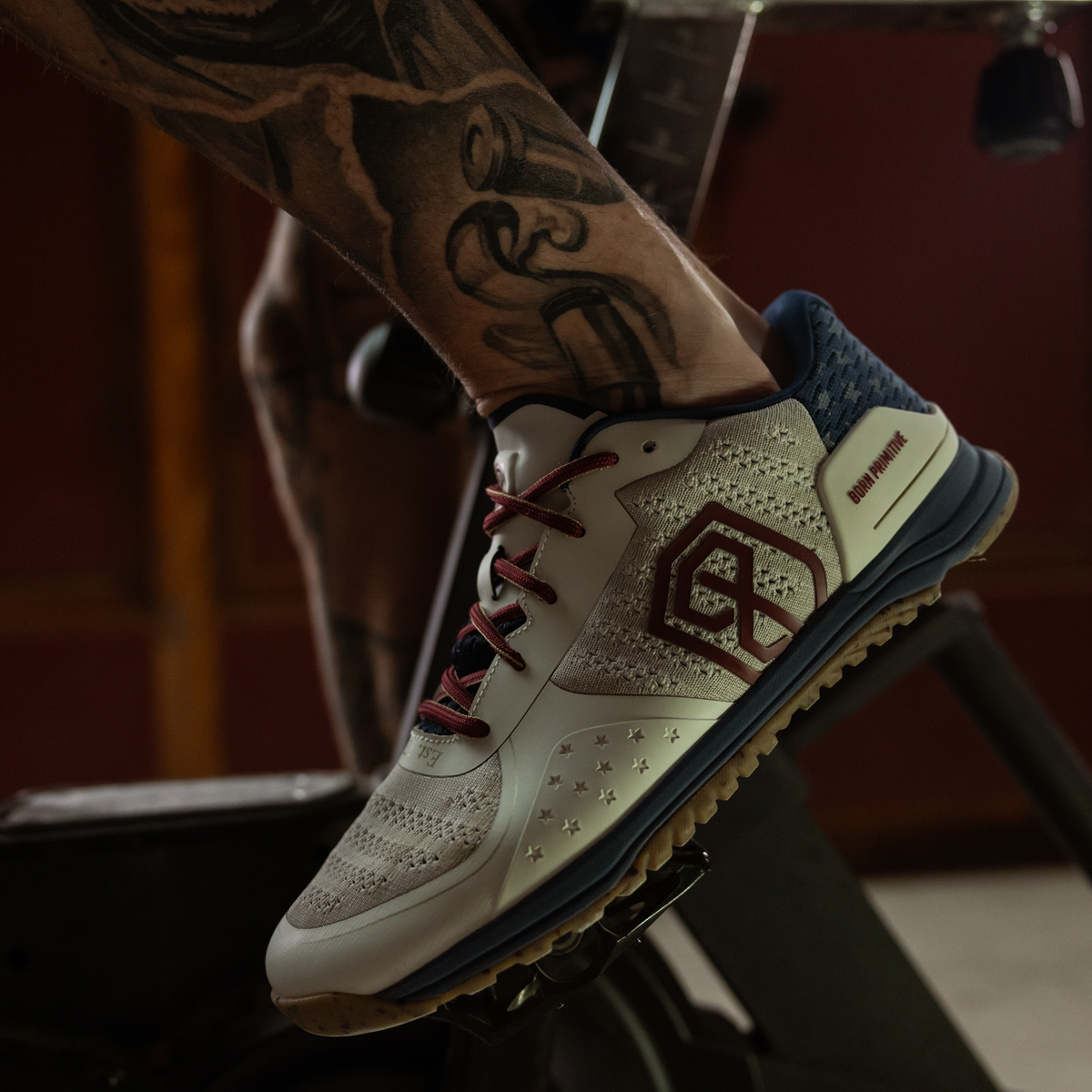 Close-up of a person wearing a sneaker with a brand logo, on a stationary bike.