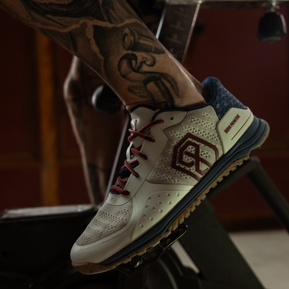 Close-up of a person wearing a sneaker with a brand logo, on a stationary bike.