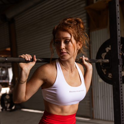 Woman lifting a barbell in a gym setting