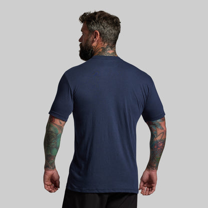 Man wearing a navy blue t-shirt on a gray background