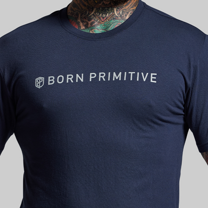 Navy blue t-shirt with 'Born Primitive' logo on a gray background