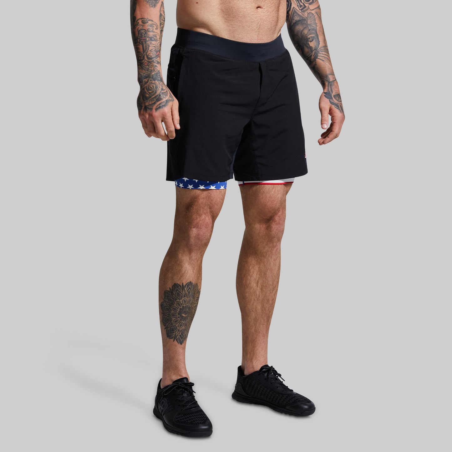 Person wearing black shorts on a gray background