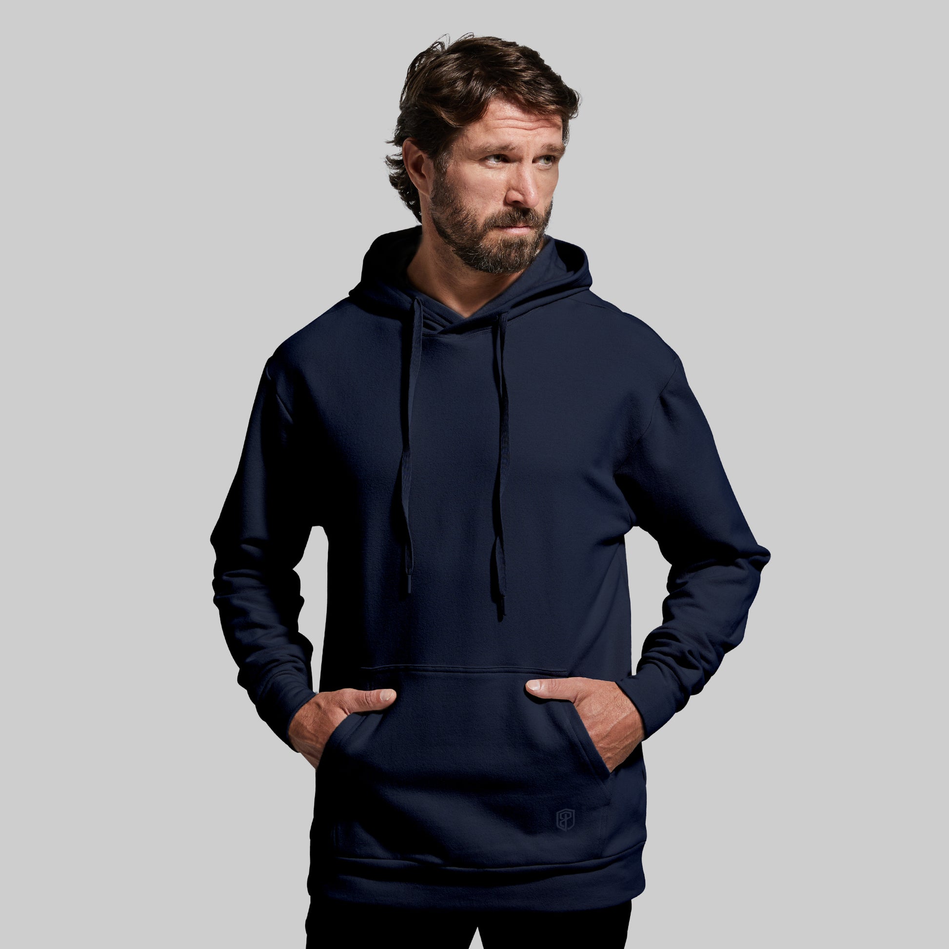 Man wearing a navy blue hoodie against a gray background