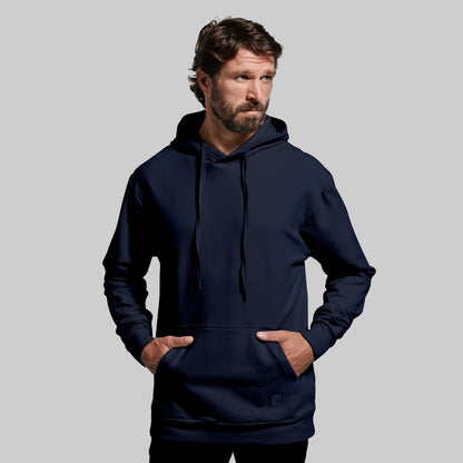 Man wearing a navy blue hoodie against a gray background