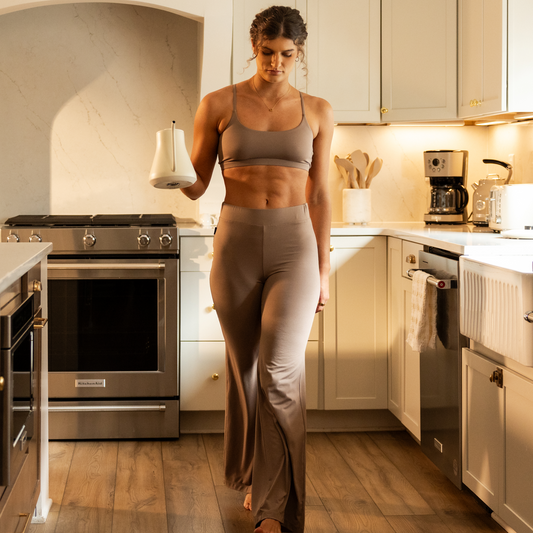 Woman in lounge wear standing in a kitchen