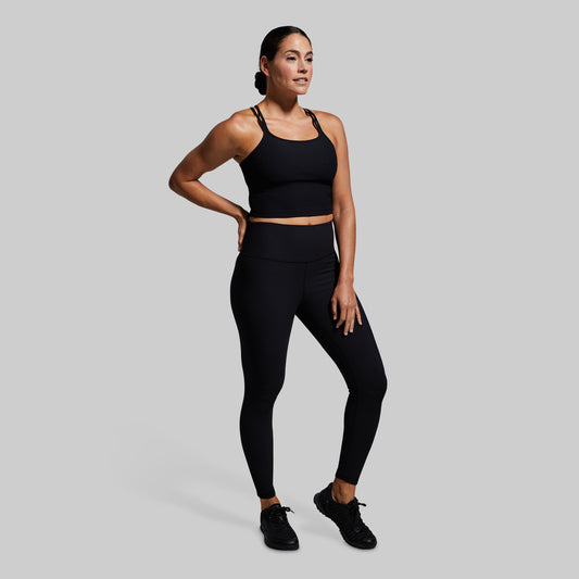 Woman wearing a black athletic outfit on a gray background
