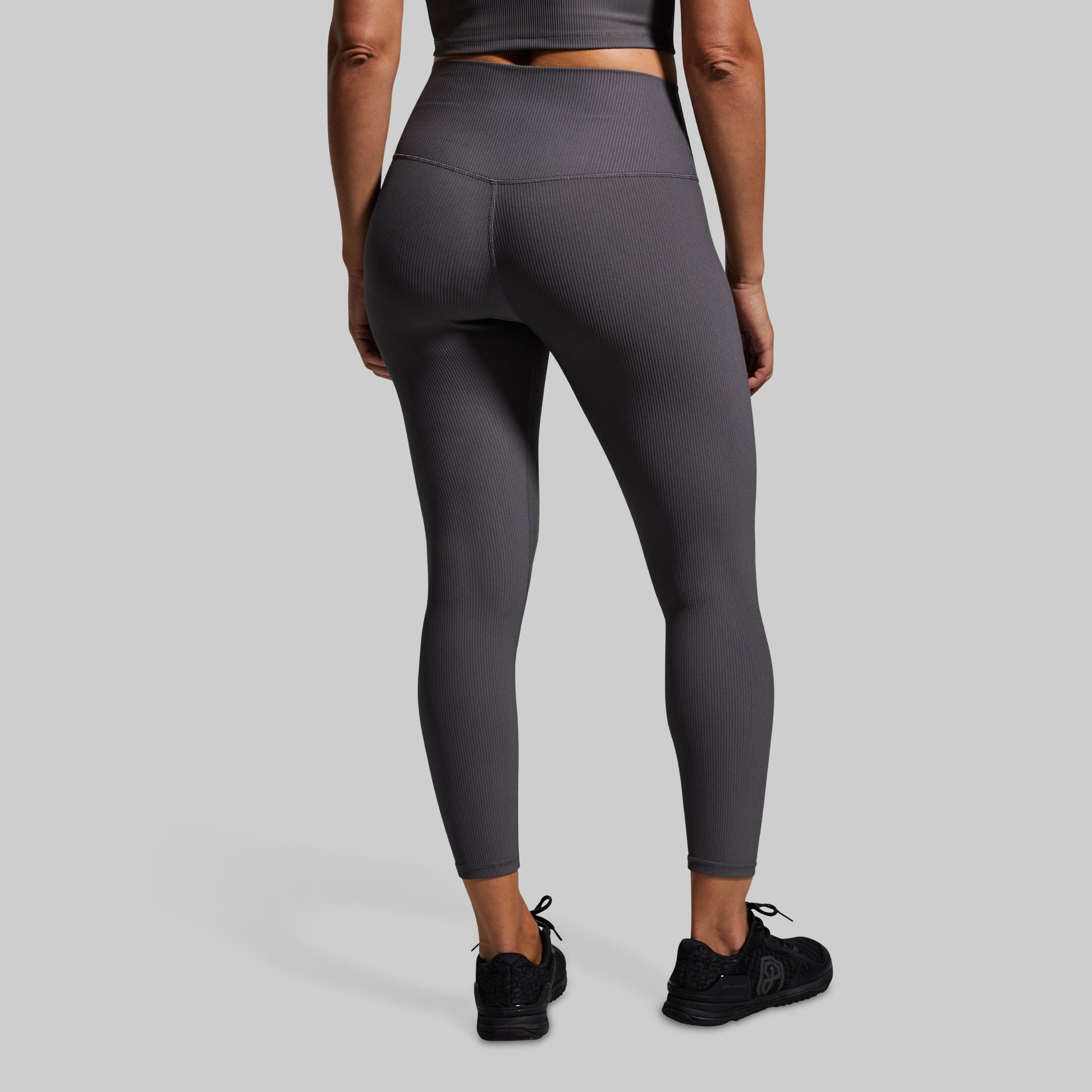 Person wearing gray leggings on a light gray background