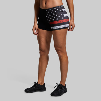 Person wearing black shorts with American flag design on a gray background
