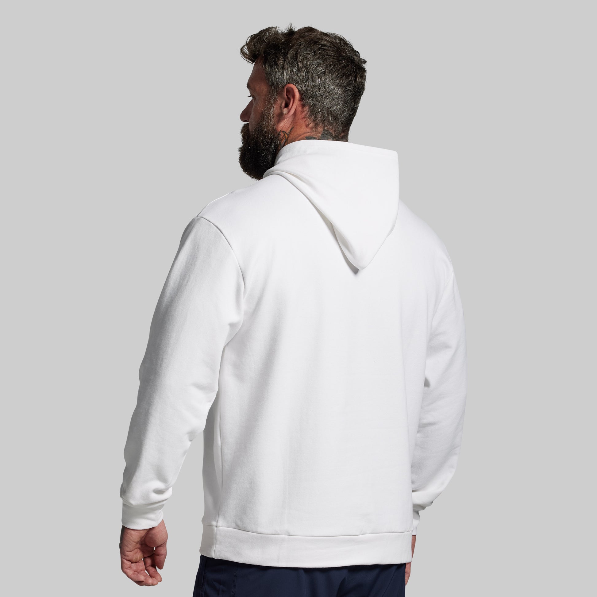 Man wearing a white hoodie against a gray background