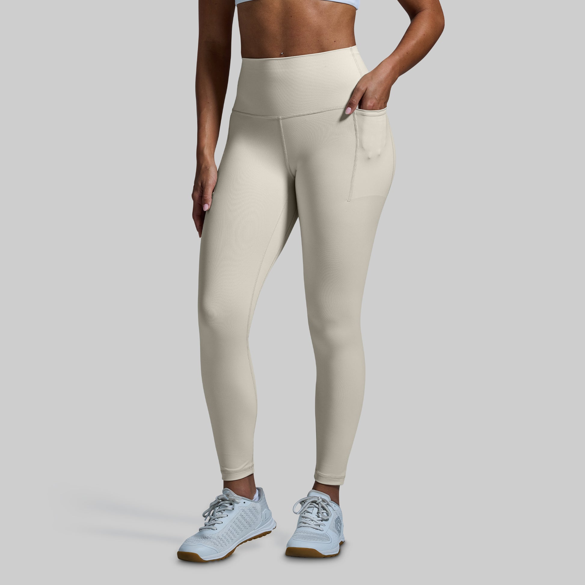 Person wearing beige leggings on a plain background
