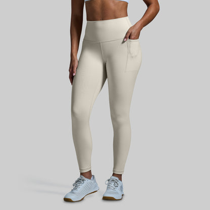 Person wearing beige leggings on a plain background