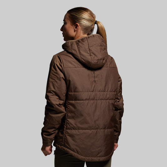 Person wearing a brown puffer jacket on a plain background