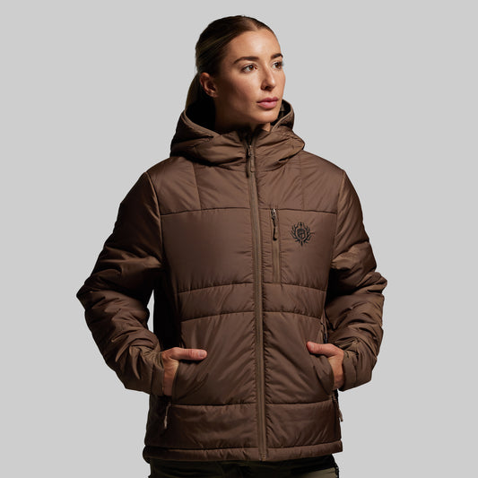 Person wearing a brown quilt patterned puffer jacket on a plain background
