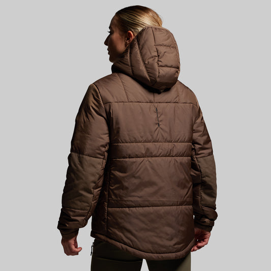 Person wearing a brown puffer jacket on a plain background