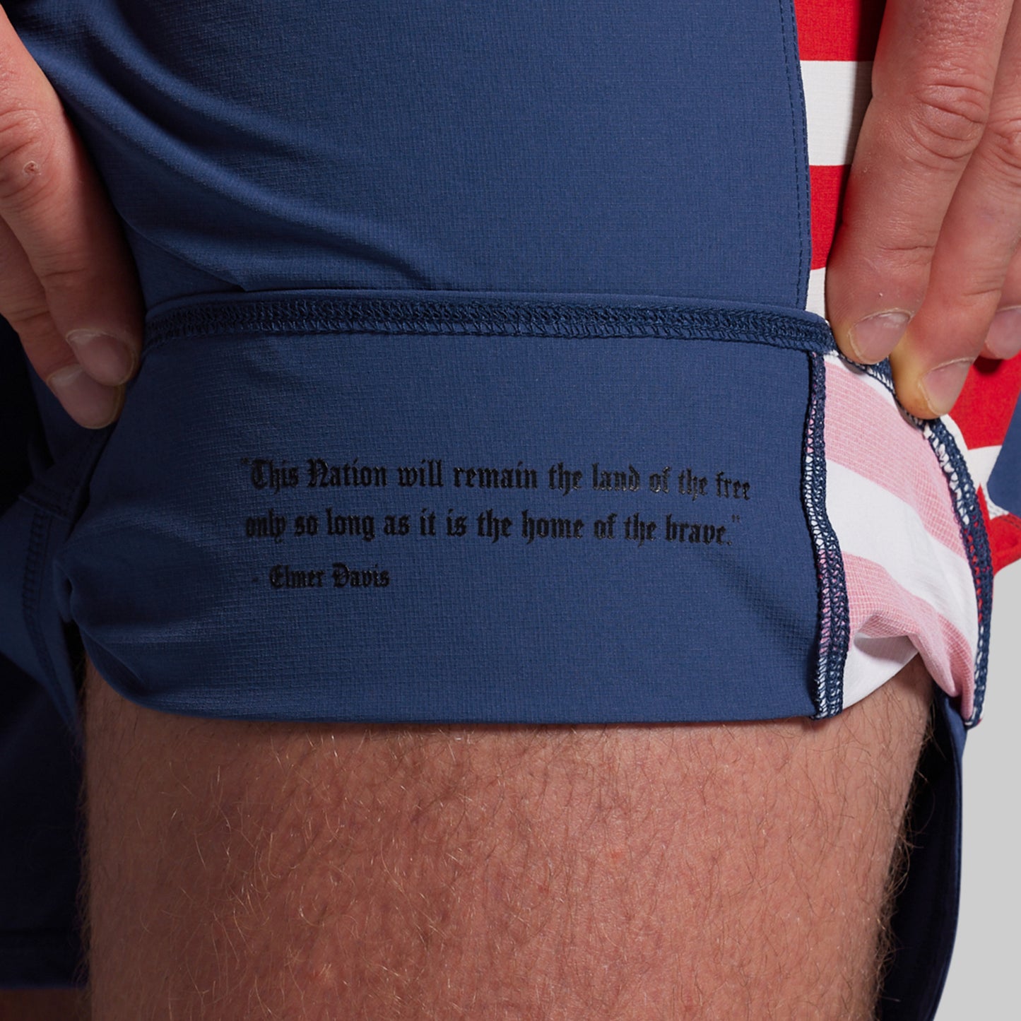Navy shorts with a quote, worn by a person.