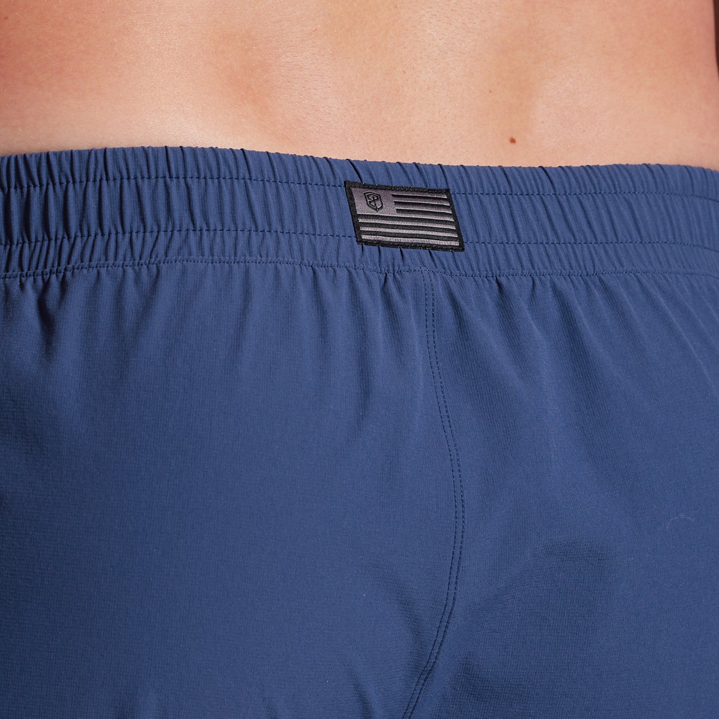 Close-up of blue shorts with a brand logo on the waistband.