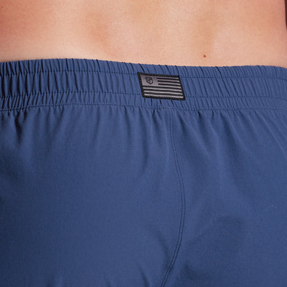 Close-up of blue shorts with a brand logo on the waistband.