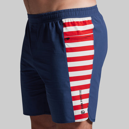 Navy shorts with a red and white striped side panel on a gray background