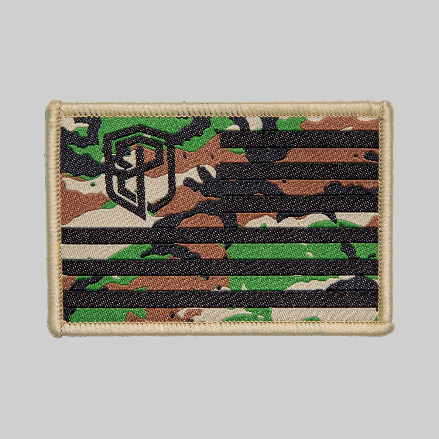 A camouflage pattern Velcro patch with the Born Primitive logo resembling an American flag design, predominantly green, black, and brown.